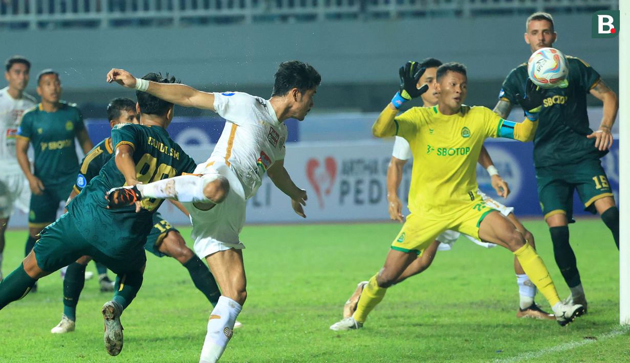 Pemain Persija Jakarta, Aji Kusuma (tengah kiri) berusaha mencetak gol melalui tandukannya ke gawang Persikabo 1973 yang dijaga Syahrul Trisna pada laga pekan kedua BRI Liga 1 2023/2024 di Stadion Pakansari, Cibinong, Bogor, Minggu (9/7/2023). (Bola.com/M Iqbal Ichsan)