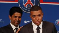 Striker Paris Saint-Germain (PSG) Kylian Mbappe (kanan) menunjukkan jerseynya dengan Presiden PSG Nasser Al-Khelaifi saat konferensi pers di Stadion Paris des Princes, Paris, Prancis, 23 Mei 2022. Keputusan Kylian Mbappe menolak Real Madrid dan berkomitmen untuk PSG selama tiga musim lagi menandai dimulainya proyek pembangunan klub juara Liga Prancis tersebut. (AP Photo/Michel Spingler)