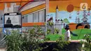 Pekerja berjalan di depan mural Kota Jakarta, Tanah Kusir, Kebayoran Lama, Jakarta, Jumat (26/11/2021). Mural tersebut bertemakan Kota Jakarta dengan gambar ikon seperti ondel-ondel, Monas hingga transportasi. (Liputan6.com/Herman Zakharia)