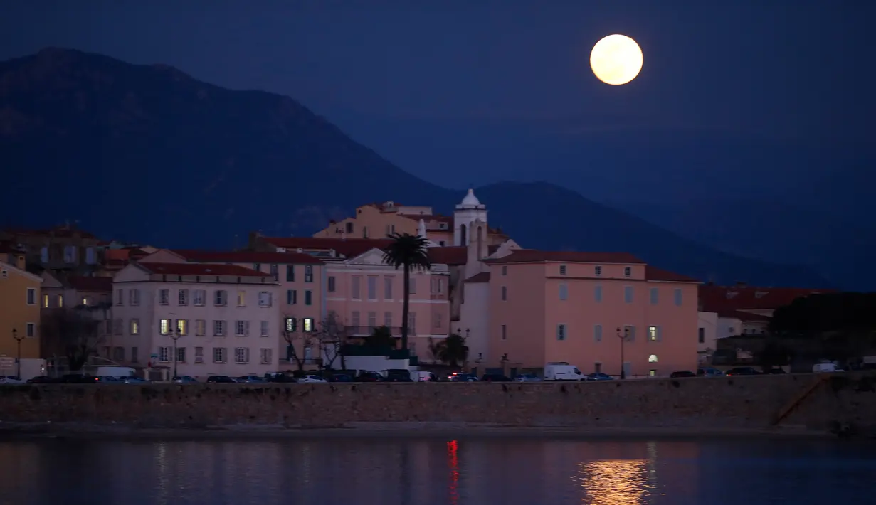 Fenomena super snow moon terlihat di atas Ajaccio, Corsica, Prancis, Selasa (19/2). Super snow moon terjadi karena orbit bulan berada di posisi paling dekat dengan Bumi. (PASCAL POCHARD-CASABIANCA/AFP)