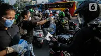 Relawan membagikan masker kepada pengguna jalan di Kawasan Bundaran HI, Jakarta, Selasa (17/3/2020). Sebanyak 3.000 masker dibagikan secara gratis sebagai salah satu bentuk keprihatinan sekaligus berpartisipasi dalam upaya mencegah penyebaran virus corona COVID-19. (Liputan6.com/Faizal Fanani)