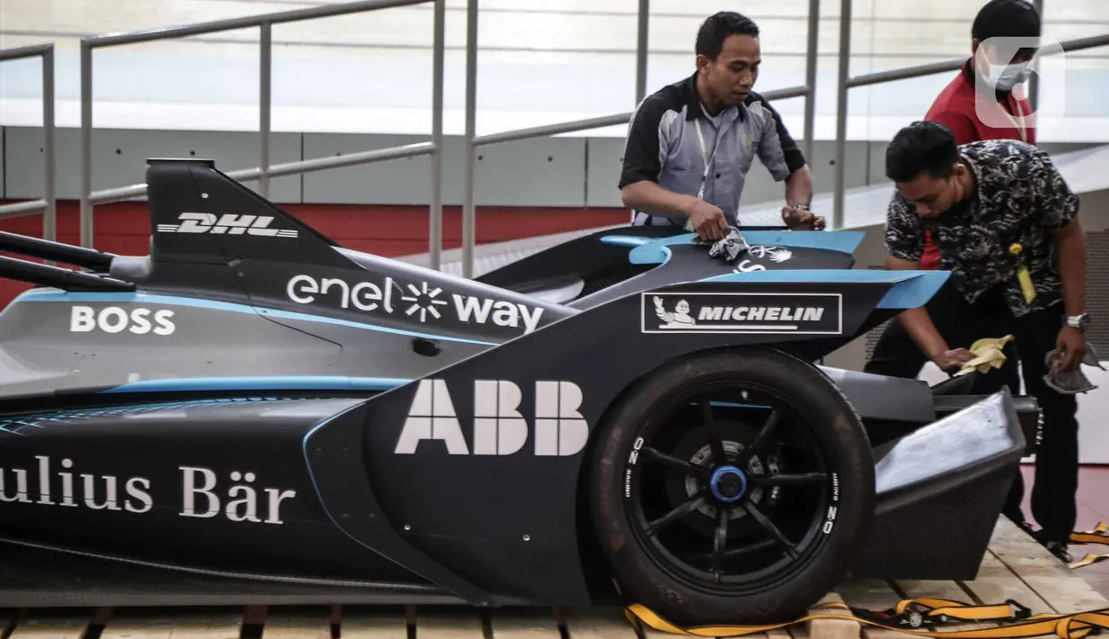 Petugas mengelap replika mobil Formula E setelah dibuka untuk kali pertama di Stadion Balap Sepeda Velodrome, Rawamangun, Jakarta Timur, pada Kamis (26/5/2022). Ini merupakan replika salah satu mobil Formula E yang akan mengaspal di Sirkuit Ancol pada 4 Juni mendatang. (Liputan6.com/Faizal Fanani)