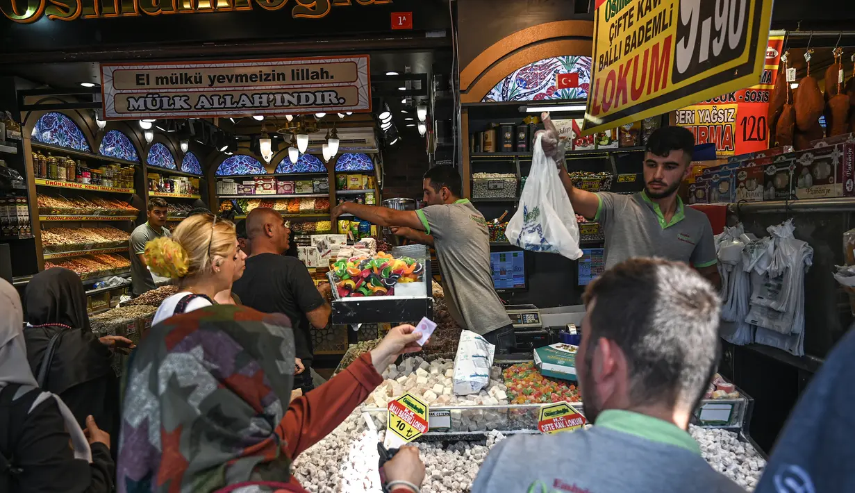 Pedagang melayani pembeli di pasar rempah-rempah atau Spice Bazaar yang bersejarah di distrik Eminonu di Istanbul, Turki (13/7/2019). Tempat tersebut menjadi spesial karena berbagai macam rempah-rempah pedas khas Turki dijual disitu. (AFP Photo/Ozam Kose)