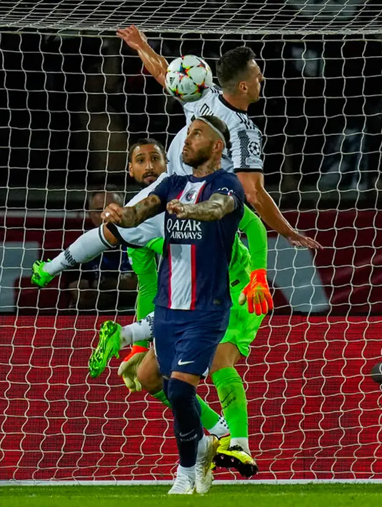 Pemain Paris Saint-Germain (PSG) Sergio Ramos (depan) berebut bola dengan pemain Juventus Arkadiusz Milik pada pertandingan sepak bola Grup H Liga Champions di Stadion Parc des Princes, Paris, Prancis, 6 September 2022. PSG mengalahkan Juventus dengan skor 2-1. (AP Photo/Thibault Camus)