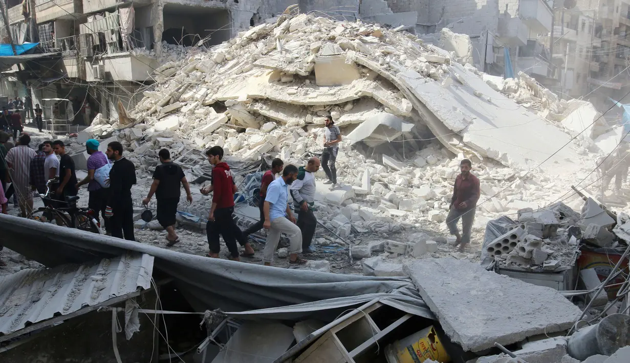 Warga mencari korban yang tertimbun di reruntuhan akibat serangan udara di distrik al-Fardous, Aleppo, Suriah, Rabu (12/10). Serangan udara terhadap kota yang dikuasai oleh pemberontak di Aleppo menewaskan sedikitnya 15 orang. (REUTERS/Abdalrhman Ismail)