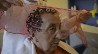 Maribel Elizondo, 90 tahun, ditata rambutnya oleh penata rambut Gloria Cerdan di salon rambut di panti jompo Ibaneta, sekitar 30 km dari Pamplona, Spanyol, Senin (22/3/2021). Setiap minggu, pada hari Senin, penata rambut Gloria Cerdan mendatangi penghuni panti jompo. (AP Photo/Alvaro Barrientos)