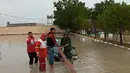 Petugas membantu menderek kendaraan yang terjebak banjir di Provinsi Hormozgan di selatan Iran (4/1/2022). Hujan lebat menyebabkan kerusakan pada lahan pertanian dan memblokir jalan di provinsi Hormozgan, dan merusak beberapa infrastruktur. (AFP/Iranian Red Crescent)