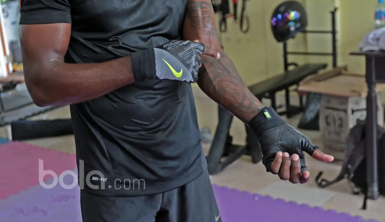Greg Nwokolo menunjukan salah satu tato miliknya saat berlatih conditioning dengan beban dan fisik di Blue Hause Gym, Jakarta Selatan. (Bola.com/Nicklas Hanoatubun)