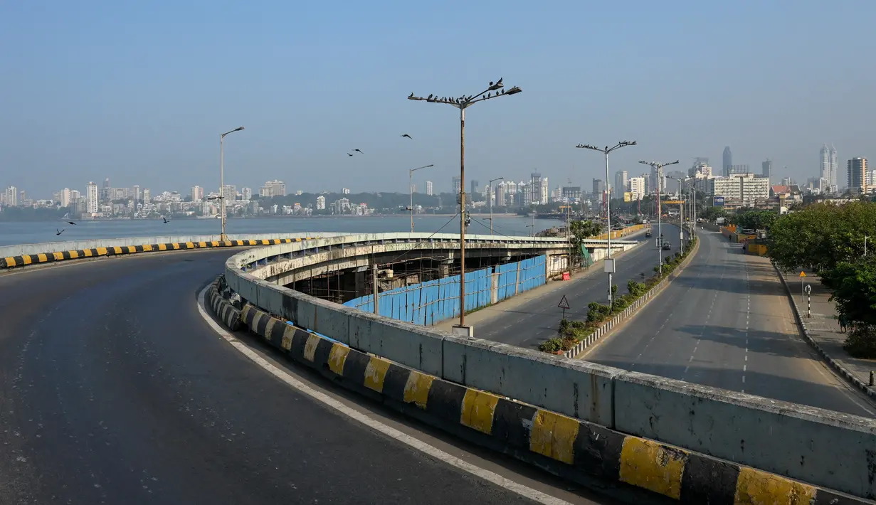 Jalan sepi di Marine Drive terlihat selama pembatasan yang diberlakukan oleh pemerintah negara bagian di tengah meningkatnya kasus corona Covid-19, di Mumbai, Kamis (15/4/2021). Kasus virus corona baru di India mencapai rekor tertinggi pada Rabu, 14 April. (Punit PARANJPE / AFP)