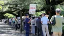 Sejumlah pengunjung mengantre untuk berfoto dan melihat bunga Bangkai dari Bengkulu yang mekar di kebun raya Jindai, Tokyo, Jepang, Rabu (22/7/2015). (AFP PHOTO/Yoshikazu TSUNO)
