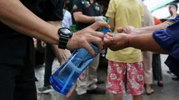 Warga membersihkan tangan menggunakan hand sanitizer saat antre Operasi Pasar di Pasar Palmerah, Jakarta, Jumat (20/3/2020). Di tengah merebaknya virus corona Perum Bulog menggelar Operasi Pasar untuk mencegah panic buying dengan harga murah. (Liputan6.com/Fery Pradolo)