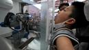 Sebuah lengan robot melakukan tes usap tenggorokan untuk mengambil sampel tes COVID-19 saat Konferensi Robot Dunia di Yichuang International Conference and Exhibition Centre, Beijing, China, 19 Agustus 2022. (AP Photo/Ng Han Guan)