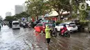 Polisi mengatur arus lalu lintas di jalan Margonda Raya yang tergenang air, Kota Depok, Jawa Barat, Jumat (29/5/2020). Tersumbatnya aliran air menyebabkan sebagian ruas jalan Margonda Raya sempat tergenang air serta menyebabkan arus lalu lintas tersendat. (LIputan6.com/Helmi Fithriansyah)