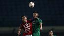 Bek PS Sleman, Arthur Daniel Irawan (kanan) berduel udara dengan gelandang Bali United, Fadil Sausu dalam laga perempatfinal Piala Menpora 2021 di Stadion Si Jalak Harupat, Bandung, Senin (12/4/2021). (Bola.com/Ikhwan Yanuar)