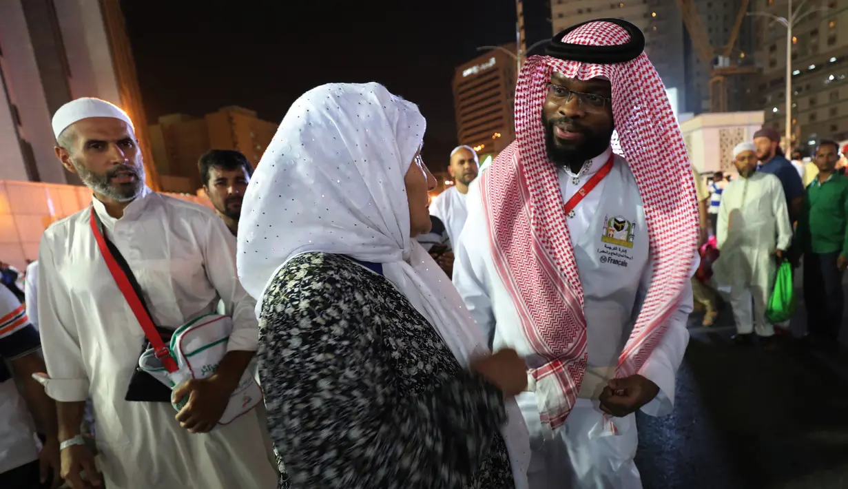 Jemaah haji berbincang dengan seorang penerjemah di kota suci Islam, Makkah, Arab Saudi, 17 Agustus 2018. Pemerintah Arab Saudi mengerahkan para penerjemah dari berbagai bahasa yang bekerja 24 jam per hari untuk membantu jemaah. (AFP/AHMAD AL-RUBAYE)