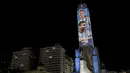 Video mapping memperlihatkan gambar bintang sepak bola Argentina Lionel Messi dan Angel Di Maria di "Monumento Nacional a la Bandera" di Rosario, Senin (21/11/2022). Proyeksi cahaya tersebut sebagai bentuk untuk menyemangati timnas Argentina sebelum menghadapi Arab Saudi dalam laga pertama Grup C Piala Dunia 2022, Selasa (22/11/2022) petang WIB. (Marcelo Manera / AFP)