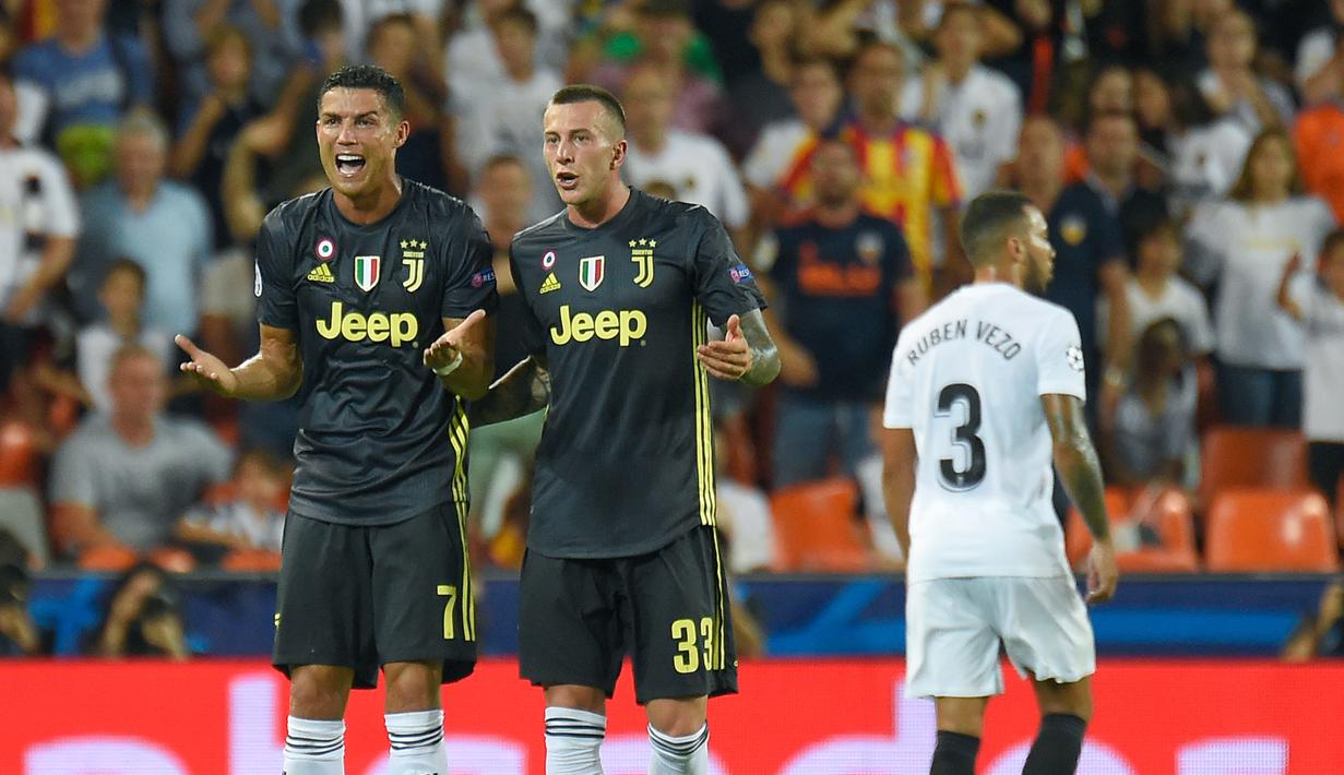Pemain Juventus, Cristiano Ronaldo bereaksi di sebelah rekan setimnya, Federico Bernardeschi setelah menerima kartu merah saat melawan Valencia pada matchday pertama Grup H Liga Champions, di Stadion Mestalla, Rabu (19/9). (JAVIER SORIANO/AFP)