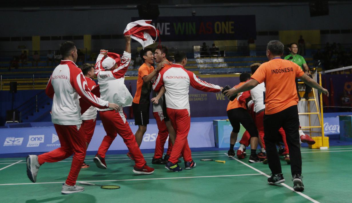 Pemain dan pelatih tim beregu putra Indonesia merayakan gelar juara cabang bulutangkis SEA Games 2019 di Multinlupa Sport Center, Rabu (4/12). Indonesia meraih emas setelah menang 3-1 atas Malaysia. (Bola.com/M Iqbal Ichsan)