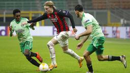 Pemain AC Milan Jens Petter Hauge (tengah) melewati pemain Celtic Jeremie Frimpong (kiri) Hatem Abd Elhamed (kanan) pada pertandingan Grup H Liga Europa di Stadion San Siro, Milan, Italia, Kamis (3/12/2020). AC Milan mengalahkan Celtic 4-2 setelah sebelumnya tertinggal. (AP Photo/Antonio Calanni)