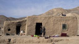 Cucu Haji Wali Jan (66) berdiri di pintu masuk rumahnya di desa Kamar Kalagh di luar Herat, Afghanistan, pada 26 November 2021. Kekeringan Afghanistan, yang terburuk dalam beberapa dekade, kini memasuki tahun kedua, diperburuk oleh perubahan iklim. (AP/Petros Giannakouris)