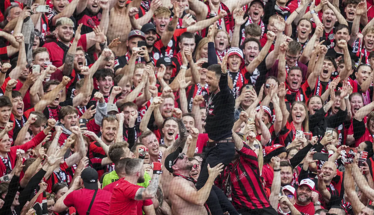 Pelatih Bayer Leverkusen, Xabi Alonso, merayakan gelar juara Bundesliga 2024 bersama suporter di BayArena, Sabtu (18/5/2024). (AP Photo/Michael Probst)