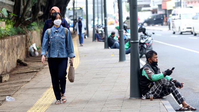 Warga berjalan di trotoar Jalan Blora, Dukuh Atas Jakarta, Kamis (21/1/2021). Untuk mencegah penyebaran virus COVID-19, pemerintah memperpanjang pemberlakuan pembatasan kegiatan masyarakat (PPKM) di Jawa-Bali selama 14 hari kedepan, mulai 26 Januari-8 Februari 2021. (Liputan6.com/Helmi Fithriansyah)