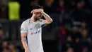 Reaksi gelandang Chelsea, Cesc Fabregas setelah pemain Barcelona, Lionel Messi mencetak gol pada leg kedua babak 16 besar Liga Champions 2017-2018 di Stadion Camp Nou, Rabu (14/3). Chelsea terhenti pada babak 16 besar Liga Champions. (Josep LAGO/AFP)