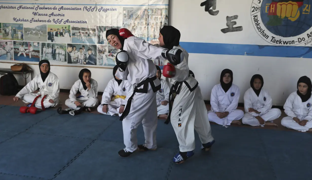 Gadis-gadis Afghanistan berlatih tanding selama sesi pelatihan taekwondo di sebuah klub swasta di Kabul, Afghanistan pada 1 Maret 2021. Latihan bela diri ini mengupayakan para perempuan di Afghanistan bisa melindungi dirinya sendiri. (AP Photo/Rahmat Gul)
