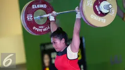 Lifter Bali, Sinta Luh Darmariani saat melakukan angkatan clean and jerk di kelas 63kg putri PON XIX Jabar di Gymnasium Si Jalak Harupat, Kab Bandung, Rabu (21/9). Sinta meraih emas dengan total angkatan 192kg. (Liputan6.com/Helmi Fithriansyah)