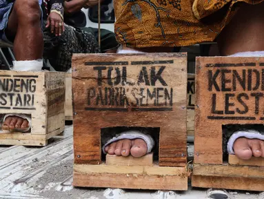 Petani dari kawasan Pegunungan Kendeng melanjutkan aksi protes memasung kaki dengan semen di depan Istana Merdeka, Kamis (16/3). Memasuki hari keempat jumlah mereka bertambah menjadi 39 petani. (Liputan6.com/Fery Pradolo)