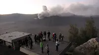 Wisatawan menyaksikan matahari terbit dengan latar belakang Gunung Bromo yang sedang erupsi di Ngadisari, Probolinggo, Jawa Timur, Rabu (6/1/2016). (REUTERS/Darren Whiteside)