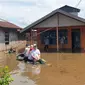 Petugas BPBD Kotawaringin Timur menyalurkan bantuan kepada keluarga yang masih bertahan di rumah yang tergenang banjir. (Foto: BPBD Kotim)