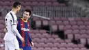 Striker Barcelona, Lionel Messi, berbincang dengan striker Juventus, Cristiano Ronaldo, pada laga Liga Champions di Stadion Camp Nou, Rabu (9/12/2020). Laga tersebut menjadi ajang reuni dua mega bintang yakni Messi dan Ronaldo. (AFP/Josep Lago)