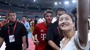Penyerang Bayern Muenchen, Thomas Mueller berselfie bersama seorang fans usai sesi latihan di Shanghai, China, (19/7/2015). Bayern mengunjungi Cina untuk menggelar Tur Pra-musim. (AFP PHOTO/JOHANNES EISELE)