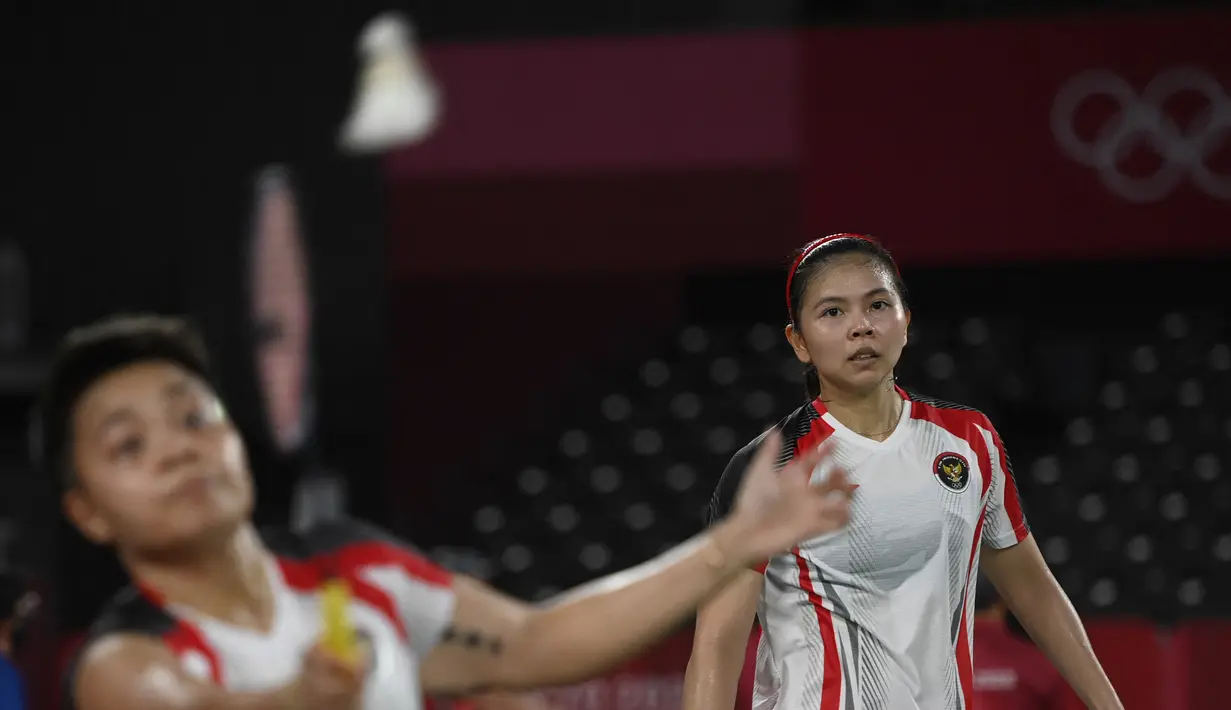 Ganda putri Indonesia Greysia Polii (kanan) dan Apriyani Rahayu saat melawan Yuki Fukushima dan Sayaka Hirota dari Jepang pada penyisihan Grup A bulu tangkis Olimpiade Tokyo 2020 di Musashino Forest Sports Plaza, (27/7/2021). Greysia / Apriyani menang 24-22, 13-21, dan 21-8. (Alexander NEMENOV/AFP)