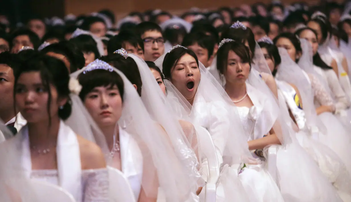Seorang pengantin wanita menguap saat menghadiri upacara pernikahan massal di Cheong Shim Peace World Center, Gapyeong, Korea Selatan, Senin (27/8). (AP Photo/Ahn Young-joon)