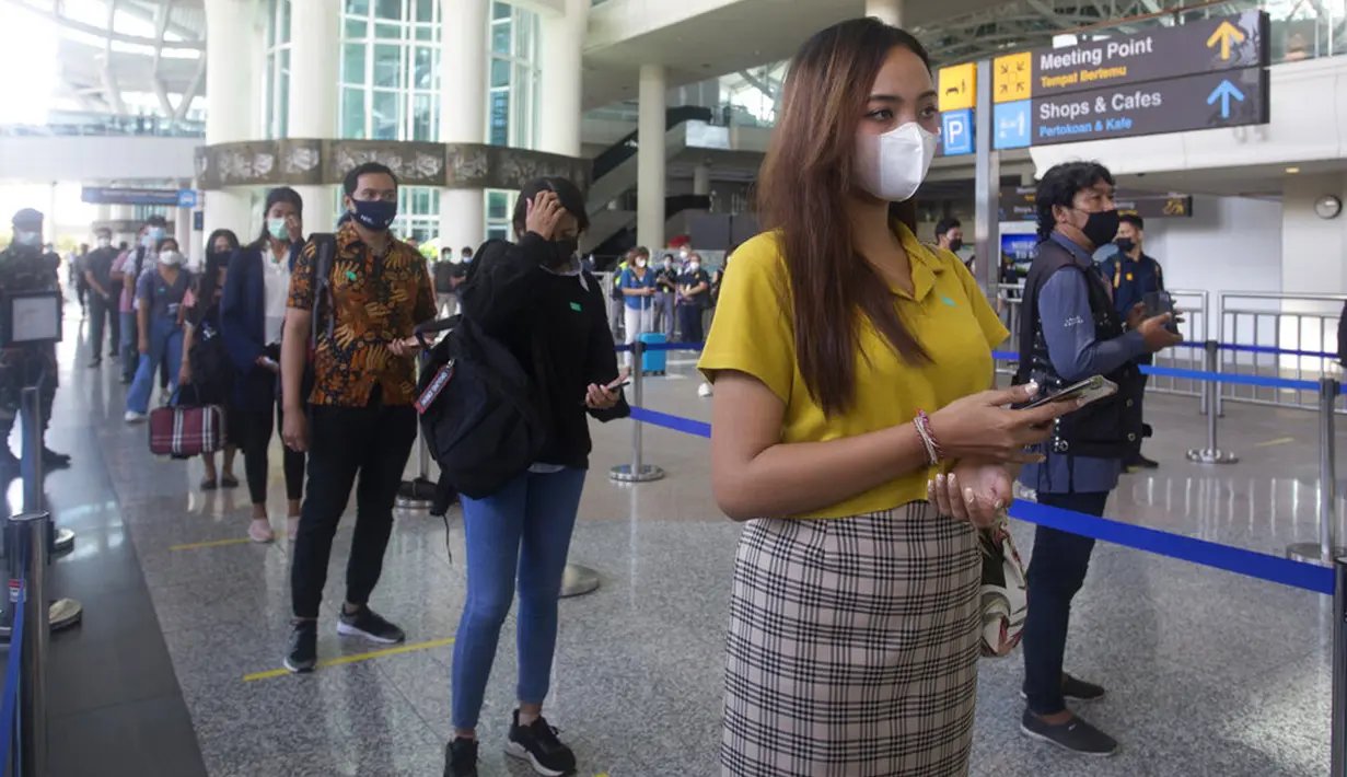 Penumpang tiruan mengantre saat latihan pembukaan kembali Bandara Internasional Ngurah Rai di Bali, Sabtu (9/10/2021). Indonesia berencana kembali membuka Bandara Internasional Ngurah Rai untuk penerbangan internasional pada 14 Oktober 2021. (AP Photo/Firdia Lisnawati)