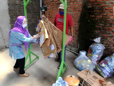 Pekerja menimbang sampah rumah tangga di bank sampah Gepe Two, Perumahan Griya Pamulang II, Tangerang Selatan, Banten, Rabu (23/12/2020). Bank sampah ini dikelola secara swadaya oleh masyarakat. (merdeka.com/Arie Basuki)