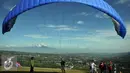 Sebuah parasut siap diterbangkan di Puncak Pass, Bogor, Jumat (6/4). Sebagian warga memanfaatkan libur panjang akhir pekan ini dengan bermain Paralayang. (Liputan6.com/Johan Tallo)