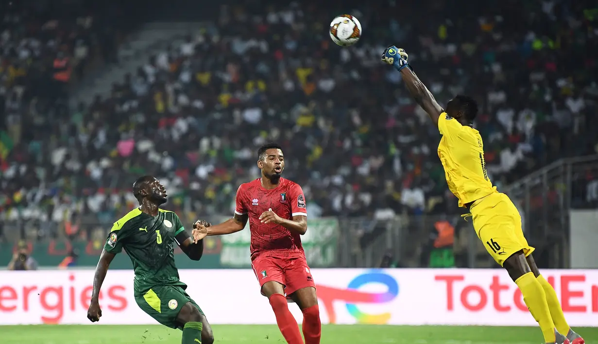 Penjaga gawang Senegal Edouard Mendy (kanan) membelokkan bola di depan gelandang Guinea Ekuatorial Jose Machin (tengah) selama pertandingan perempat final Piala Afrika (CAN) 2021 di Stade Ahmadou Ahidjo di Yaounde (31/1/2022). Senegal menang atas Guinea Ekuatorial 3-1. (AFP/Charly Triballeau)