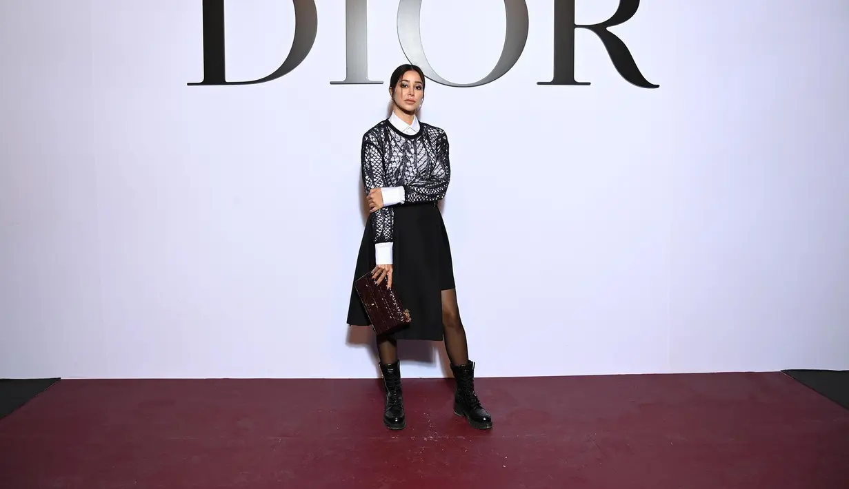 Tampak hadir juga Aseel Omran yang mengenakan koleksi dari Dior Pre Fall 2022, yaitu black lace wool blend knit dengan kemeja katun putih polos, yang dipadunya dengan black wool skirt dan black biker shorts. Foto: Document/Dior.
