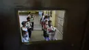 Para siswa menunggu instruksi untuk masuk ruang kelas pada hari pertama kembali ke kelas tatap muka sejak dimulainya pembatasan pandemi COVID-19 di sebuah sekolah umum di Caracas, Venezuela, 25 Oktober 2021. (AP Photo/Ariana Cubillos)