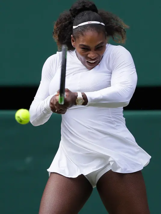 Petenis AS, Serena Williams melakukan servis ke arah petenis Jerman, Julia Gorges pada semifinal Wimbledon 2018 di London, Kamis (12/7). Mantan petenis nomor 1 dunia itu melaju ke semifinal usai mengalahkan Goerges 6-2, 6-4. (AP/Kirsty Wigglesworth)