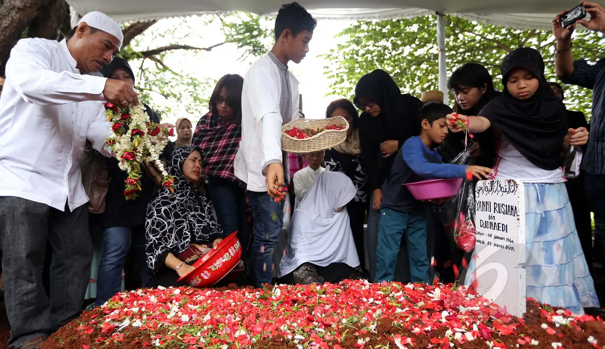 Keluarga dan kerabat menaburkan bunga di atas makam Yanni Libels di TPU Tanah Kusir, Jakarta, Kamis (26/3/2015). Yanni Libels meninggal pada hari Rabu (25/3) di Bandara Soekarno Hatta. (Liputan6.com/Panji Diksana)