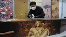 Seorang pekerja memperbaiki sekrup pada peti mati kertas di pabrik LifeArt di Hong Kong, Jumat, 18 Maret 2022. Hong Kong kekurangan peti mati selama wabah paling mematikan dari pandemi virus corona covid-19, yang telah menelan sekitar 6.000 nyawa sepanjang tahun ini. (AP Photo/Kin Cheung)