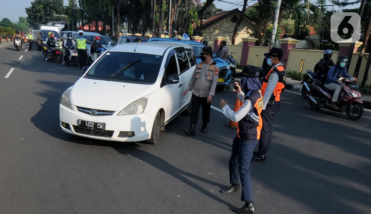 Petugas memeriksa identitas pengendara dalam rangka Pemberlakuan Pembatasan Kegiatan Masyarakat (PPKM) Darurat di pos penyekatan Pasar Jumat, Jakarta, Sabtu (3/7/2021). Polda Metro Jaya menyiapkan 63 titik penyekatan selama penerapan PPKM Darurat di Jakarta dan sekitarnya. (merdeka.com/Arie Basuki)