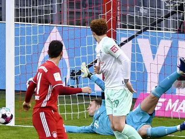 Kiper Bayern Munich, Manuel Neuer, berhasil menepis tendangan pemain Werder Bremen dalam laga lanjutan Liga Jerman pekan ke-8 di Allianz Arena, Sabtu (21/11/2020). Bayern bermain imbang 1-1 dengan Werder Bremen. (AFP/Lukas Barth/Pool)
