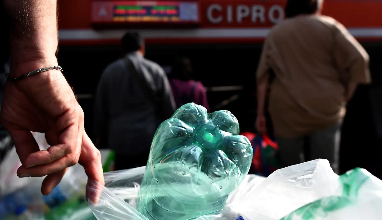 Penumpang antre menukarkan sampah botol plastik dengan tiket kereta menggunakan mesin daur ulang di stasiun metro bawah tanah Cipro, Roma, Selasa (8/10/2019). Setiap 30 sampah botol plastik, warga akan mendapatkan satu tiket yang berlaku untuk 100 menit perjalanan kereta. (Tiziana FABI/AFP)