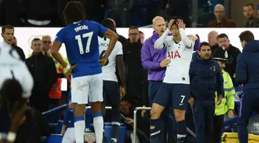 Striker Tottenham Hotspur Son Heung-min (tengah) memegangi kepalanya setelah menekel gelandang Everton Andre Gomes pada pertandingan Liga Inggris di Goodison Park, Liverpool, Inggris, Minggu (3/11/2019). Tekel Son Heung-min menyebabkan Andre Gomes patah kaki. (Oli SCARFF/AFP)