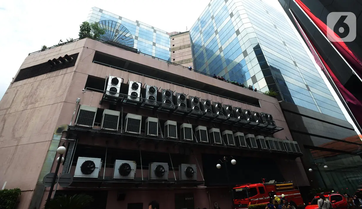 Pegawai berhamburan di luar Gedung Kemenkumham saat terjadi kebakaran, Jakarta, Kamis (8/12/2022). Ada 26 unit mobil dan 130 personel pemadam yang dikerahkan untuk memadamkan api di lokasi. (merdeka.com/Imam Buhori)